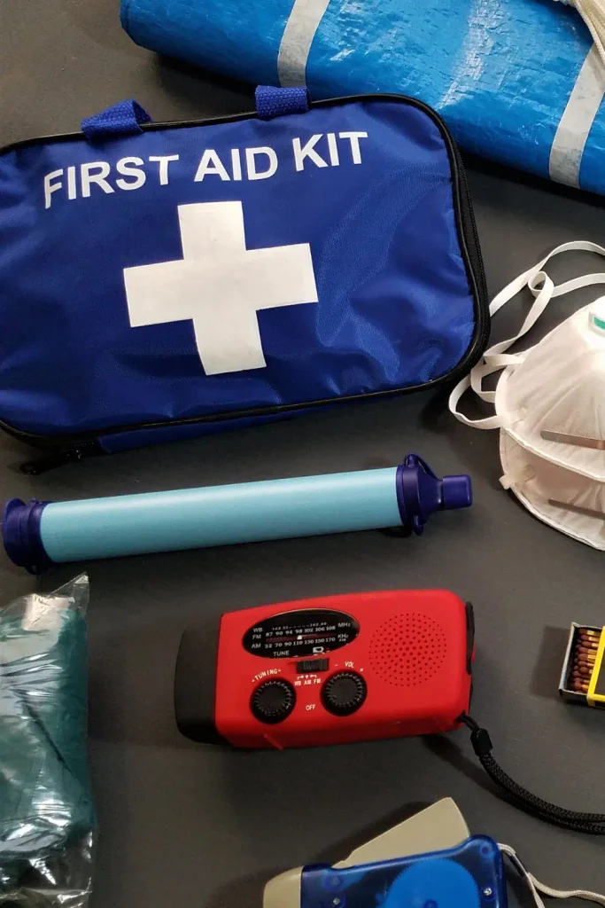 First aid kit, dust mask, water filter straw, emergency radio, and other survival supplies laid out